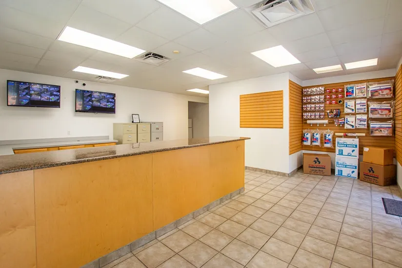 Storage office with customer service desk, security monitoring, and moving supplies